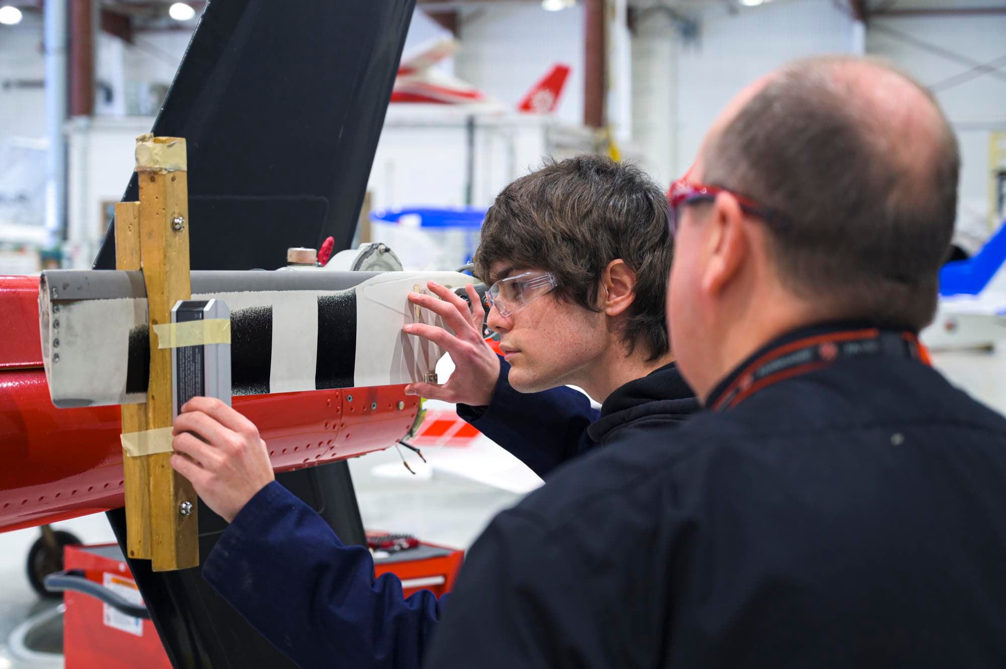 Estudiante de Aviation Technology - Aircraft Maintenance and Avionics trabajando con ayuda de un instructor en laboratorio, Fanshawe College