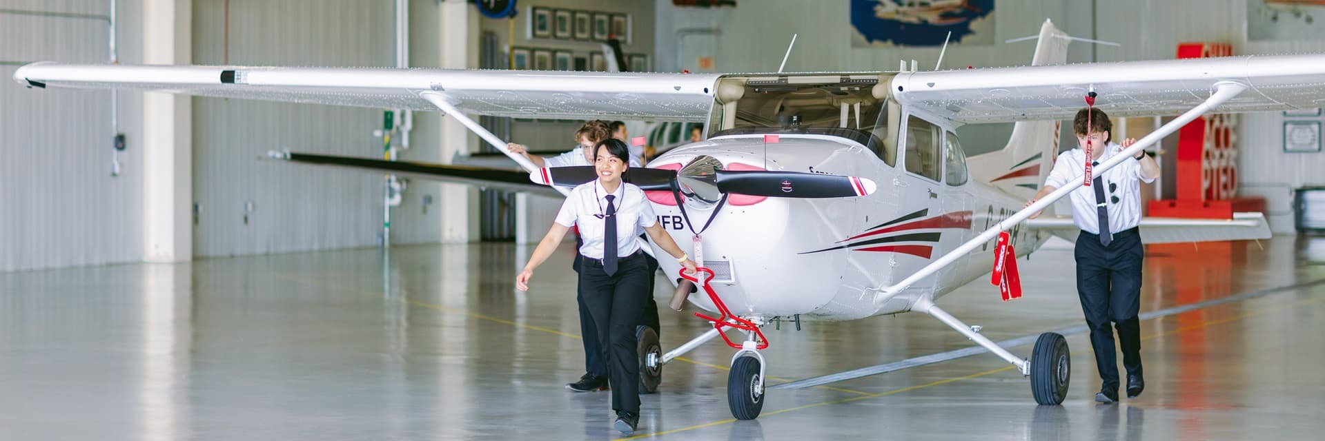 Estudiantes de Seneca Polytechnic sacando un Cessna del hangar en el Peterborough Aviation Campus